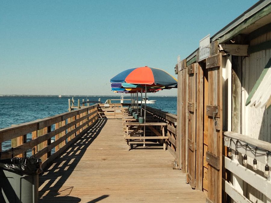 The boardwalk and umbrellas at Dewey Destin's Seafood Restaurant